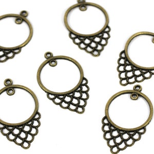 Könnte beinhalten: Sechs antike goldfarbene Ohrringrohlinge aus Metall mit einem dekorativen Filigranmuster. Jeder Rohling hat einen runden Reifen mit einer kleinen Schlaufe oben zum Anbringen einer Fassung.