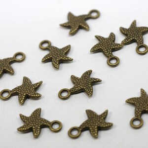May include: Ten bronze starfish charms with a loop for attaching to jewelry or other crafts. The charms are about 1 inch in size and have a textured surface.