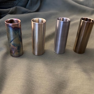 Peut inclure: Quatre diapositives de guitare slide en métal dans différentes finitions. Une diapositive est de couleur cuivre avec un motif marbré. Les trois autres diapositives sont argentées, argentées brossées et dorées.