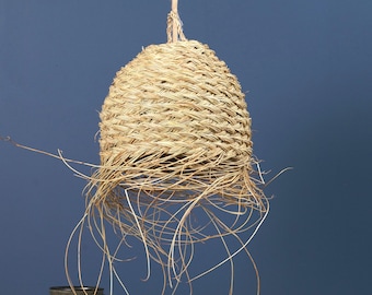 May include: A dome-shaped pendant light shade crafted from woven natural straw fibers. The structure features a tight, braided pattern on the upper section, transitioning into loose, long, dangling straw strands at the bottom edge.