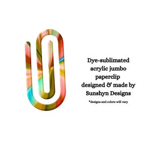 May include: A jumbo paperclip made of dye-sublimated acrylic with a multicolored abstract pattern. The text reads: Dye-sublimated acrylic jumbo paperclip designed & made by Sunshyn Designs *designs and colors will vary.