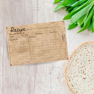Puede incluir: Una tarjeta de receta en blanco con textura de papel marr&oacute;n. La tarjeta tiene l&iacute;neas para escribir los ingredientes, las instrucciones, el tiempo de preparaci&oacute;n, el tiempo de cocci&oacute;n y el tiempo de horno. La tarjeta tiene la palabra "Receta" escrita en cursiva en la parte superior.