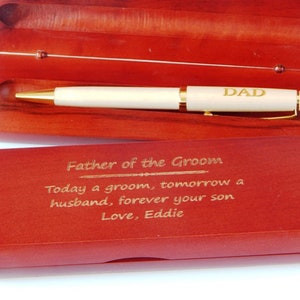May include: A wooden box with a gold pen inside. The pen has the word "DAD" engraved on it. The box has an engraved message that reads "Father of the Groom Today a groom, tomorrow a husband, forever your son Love, Eddie".