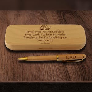 May include: A light-colored wooden pen case engraved with the text Dad, In your eyes; I've seen God's love, In your words; I've heard His wisdom, Through your life; I've found His grace. THANK YOU! Love, Heather, and a matching wooden pen.