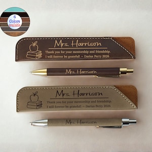 May include: Two personalized pen sets with matching pen holders. The holders are brown and tan leather with an apple and book design. The pens and holders are engraved with "Mrs. Harrison" and a thank you message.
