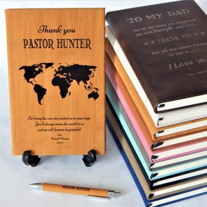 K&ouml;nnte beinhalten: Eine Holzplakette mit einer Weltkarte und dem Text "Thank you Pastor Hunter" darauf graviert. Die Plakette steht auf einem kleinen Holzst&auml;nder. Ein Stift mit dem Text "Pastor Hunter" ist ebenfalls im Bild.
