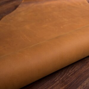 May include: A close-up of a rolled piece of brown leather. The leather has a natural, rustic look and feel.
