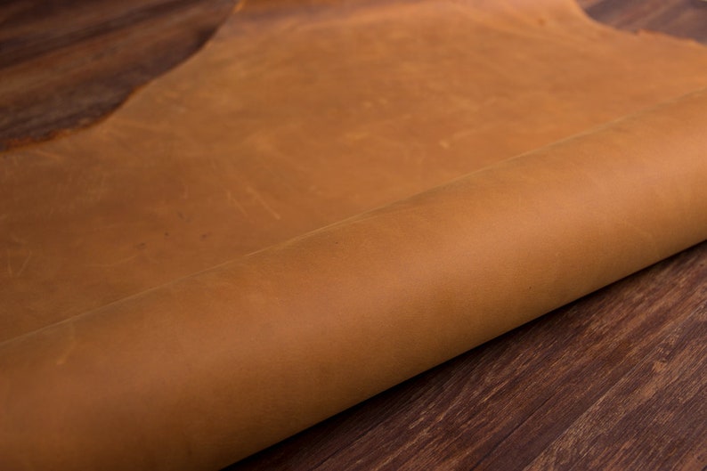 May include: A close-up of a rolled piece of brown leather. The leather has a natural, rustic look and feel.