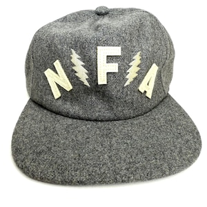 May include: A gray wool baseball cap with a curved brim. The cap features the letters "NFA" in white, with lightning bolt accents. The hat is a classic style, suitable for casual wear.