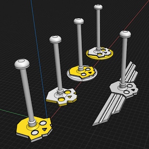 Pode incluir: Cinco suportes de exibição de plástico branco com bases amarelas. Cada base apresenta um design diferente, incluindo uma caveira e ossos cruzados, uma caveira com asas e uma caveira com um círculo ao redor.
