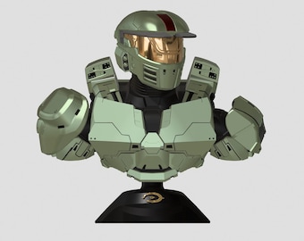 Puede incluir: Un busto verde y dorado de Master Chief de la serie de videojuegos Halo. El busto está sobre una base negra con el logotipo de Halo.