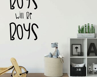 May include: A white wall with a black vinyl decal that reads "Boys will be Boys". The wall is decorated with a toy storage basket, a stuffed animal, and a shelf with a picture frame and a letter A.
