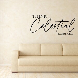 Black vinyl decal with the text "Think Celestial Russel M. Nelson" quote. Set on the wall above a couch in a modern living room.