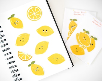 Könnte beinhalten: Ein Set gelber Zitronenaufkleber mit süßen Gesichtern. Die Aufkleber befinden sich auf einem weißen Notizbuch und einer weißen Karte mit dem Text "Lemon Pack @danifeelsgood".