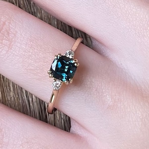 Anillo de compromiso de oro amarillo de 14 quilates con zafiro bicolor verde azulado y diamantes.