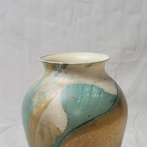May include: A large, round, ceramic vase with a marbled design in shades of brown, green, and white. The vase has a wide opening and a rounded base.