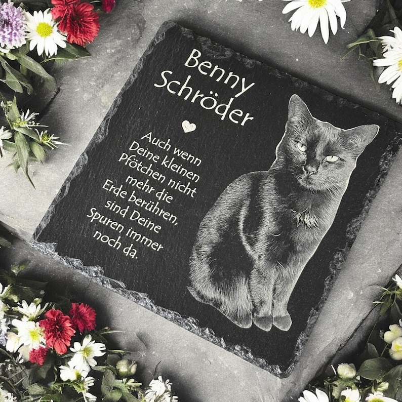 Puede incluir: Placa conmemorativa para mascotas de pizarra negra con el nombre "Benny Schr&ouml;der" y una ilustraci&oacute;n de gato. La inscripci&oacute;n dice: "Aunque tus peque&ntilde;as patas ya no toquen la tierra, tus huellas siguen ah&iacute;."