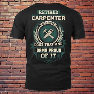 May include: Black t-shirt with a teal and white graphic. The graphic reads "Retired Carpenter Been There Done That And Damn Proud Of It." The design includes a hammer and saw crossed over each other.
