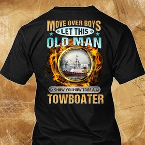 May include: Black t-shirt with the text "MOVE OVER BOYS LET THIS OLD MAN SHOW YOU HOW TO BE A TOWBOATER". The design includes a circular image of a towboat surrounded by flames.