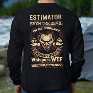 May include: Black sweatshirt with a graphic on the back. The graphic features a devil face with the text "Estimator Even The Devil On My Shoulder Sometimes Whispers WTF Are You Upto Now" in a distressed font.