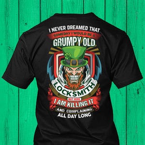 Puede incluir: Camiseta negra con un diseño de un duende con un sombrero verde. El texto dice: "I NEVER DREAMED THAT SOMEDAY I WOULD BE A GRUMPY OLD LOCKSMITH BUT HERE I AM KILLING IT AND COMPLAINING ALL DAY LONG."