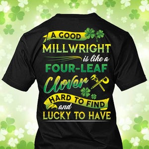 Puede incluir: Camiseta negra con un diseño verde y amarillo. El texto dice "A GOOD MILLWRIGHT is like a FOUR-LEAF Clover HARD TO FIND and LUCKY TO HAVE" con ilustraciones de tréboles y herramientas. La camiseta es de cuello redondo.