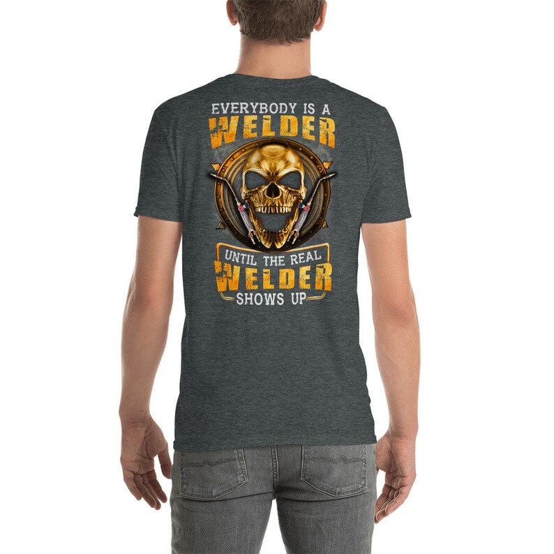 May include: A dark heather grey t-shirt with a skull graphic and the text "Everybody is a Welder Until the Real Welder Shows Up".