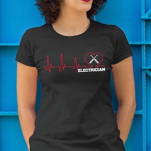 May include: Black t-shirt with a red heartbeat line graphic and a heart with crossed screwdrivers. The word "ELECTRICIAN" is printed in white below the heart graphic.