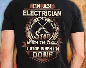 May include: A black short-sleeved t-shirt featuring a graphic on the back with the text I'M AN ELECTRICIAN I DON'T STOP WHEN I'M TIRED I STOP WHEN I'M DONE. The design includes a central illustration of two crossed screwdrivers in a circular frame.