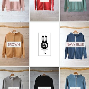 K&ouml;nnte beinhalten: Neun Kapuzenpullover in verschiedenen Farben, jeder mit einem Rei&szlig;verschluss. Die Farben sind rosa, rot, gr&uuml;n, braun, marineblau, grau, schwarz und blau. Die Pullover haben eine wei&szlig;e Umrandung an der Kapuze. Das Logo "USZY TE" ist in der Mitte des Bildes sichtbar.