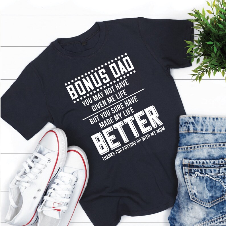 May include: A navy blue t-shirt with white text that reads "Bonus Dad... You may not have given me life but you sure have made my life better. Thanks for putting up with my mom."