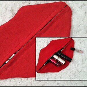 May include: Red fabric zippered pouch shaped like a pair of lips. The pouch is open and contains several lipstick tubes and a clear tube of lip gloss.