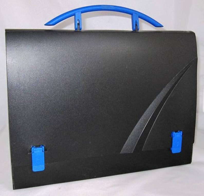 K&ouml;nnte beinhalten: Ein schwarzer, ausklappbarer Aktenordner aus Kunststoff mit einem blauen Griff und blauen Verschl&uuml;ssen. Der Ordner hat ein abgerundetes Design auf der Vorderseite.