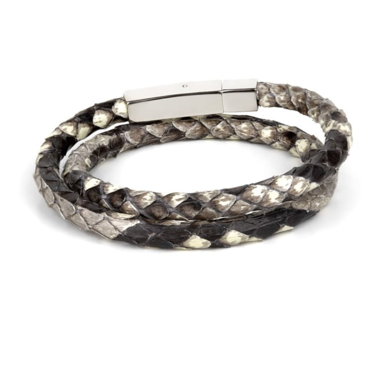 May include: A double-wrap bracelet made of black and white snakeskin with a silver clasp.
