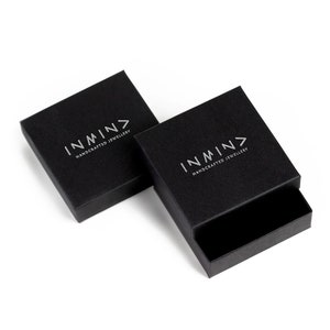 May include: Two black square boxes with the logo "INMN> HANDCRAFTED JEWELLERY" printed in silver on the top of each box.
