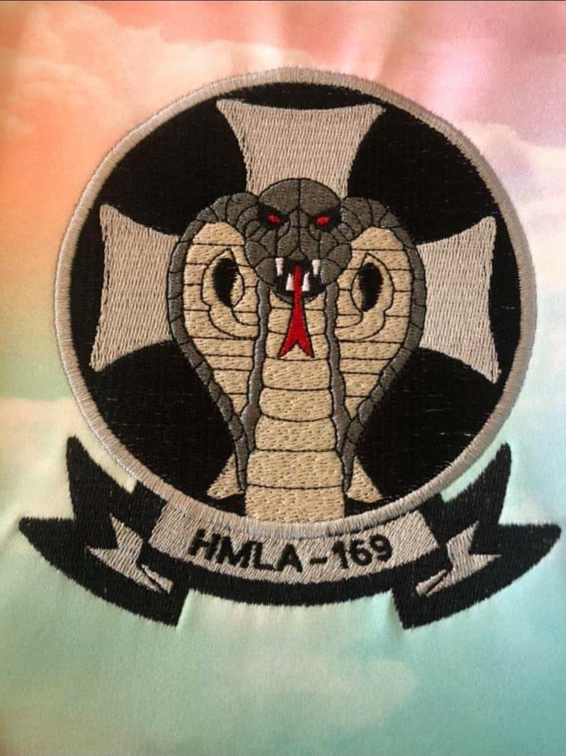 Custom embroidery digitizing service example – company logo stitched on whtie fabric.