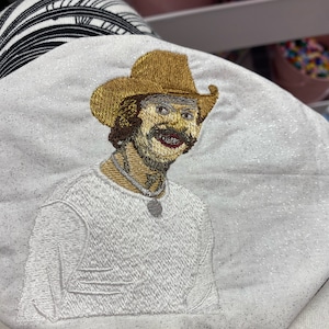 Stitched result of a custom artwork of a southern man digitized for embroidery, showing fine detail and vibrant color accuracy.