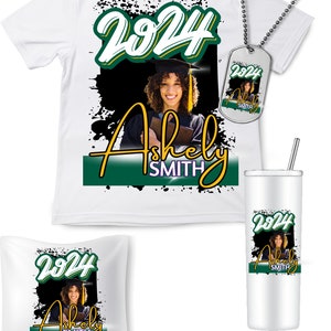 May include: A collection of graduation-themed items featuring a smiling graduate. Includes a white t-shirt, dog tag, pillow, and tumbler. Each item displays the year "2024" and the name "Ashely Smith" in a green and gold design against a black background.