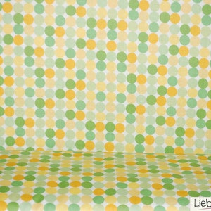 Könnte beinhalten: Ein weißer Hintergrund mit einem sich wiederholenden Muster aus gelben, grünen und hellgrünen Kreisen. Die Kreise sind in einem versetzten Muster angeordnet.