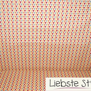 Könnte beinhalten: Ein Stoff mit einem sich wiederholenden Muster aus kleinen Dreiecken in Rot-, Orange-, Gelb- und Blautönen. Der Hintergrund ist hellcremefarben.
