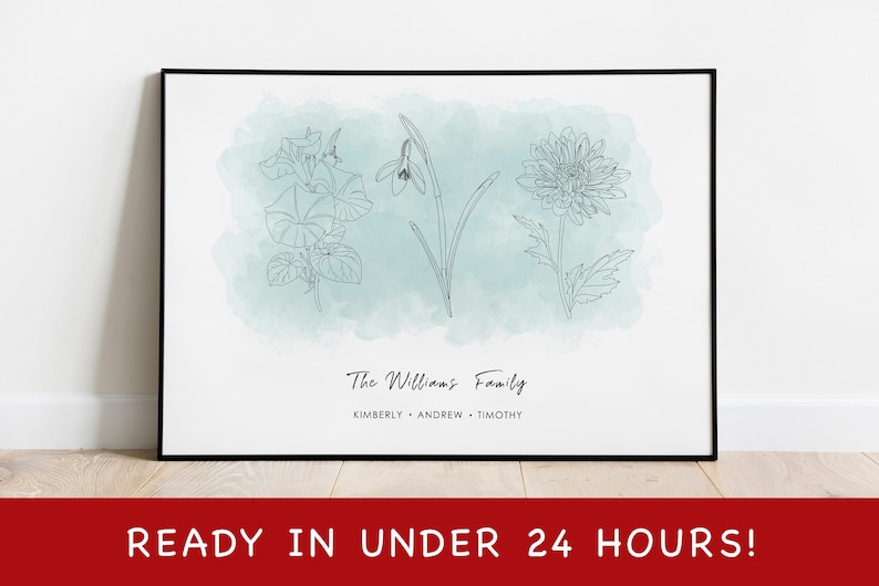 Puede incluir: Un cuadro enmarcado con dibujos lineales de tres flores sobre un fondo de acuarela azul claro. El texto "The Williams Family" est&aacute; sobre los nombres Kimberly, Andrew y Timothy. La parte inferior del marco dice "READY IN UNDER 24 HOURS!"