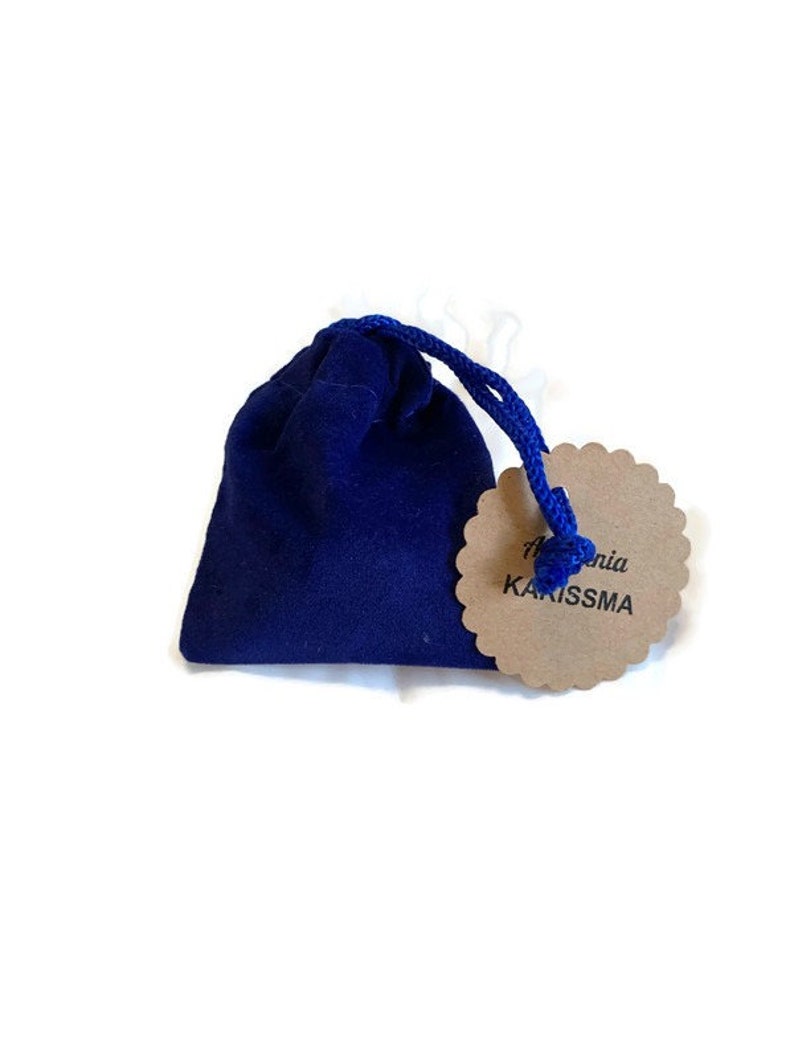May include: A small blue velvet bag with a brown tag that says "Alchemia Karissma".