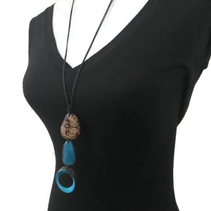 May include: A long black leather cord necklace with three turquoise and brown pendant charms. The charms are shaped like a circle, an oval, and a teardrop.