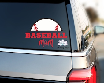 May include: A red and white baseball decal with the text "BASEBALL mom" on a gray car window. The decal also includes a small floral design with the text "The Pretty Penny Vinyl Decals".