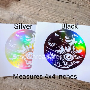 May include: Two 4x4 inch vinyl stickers featuring a black and white silhouette of a Pokemon character against a holographic background. The stickers are available in silver and black.