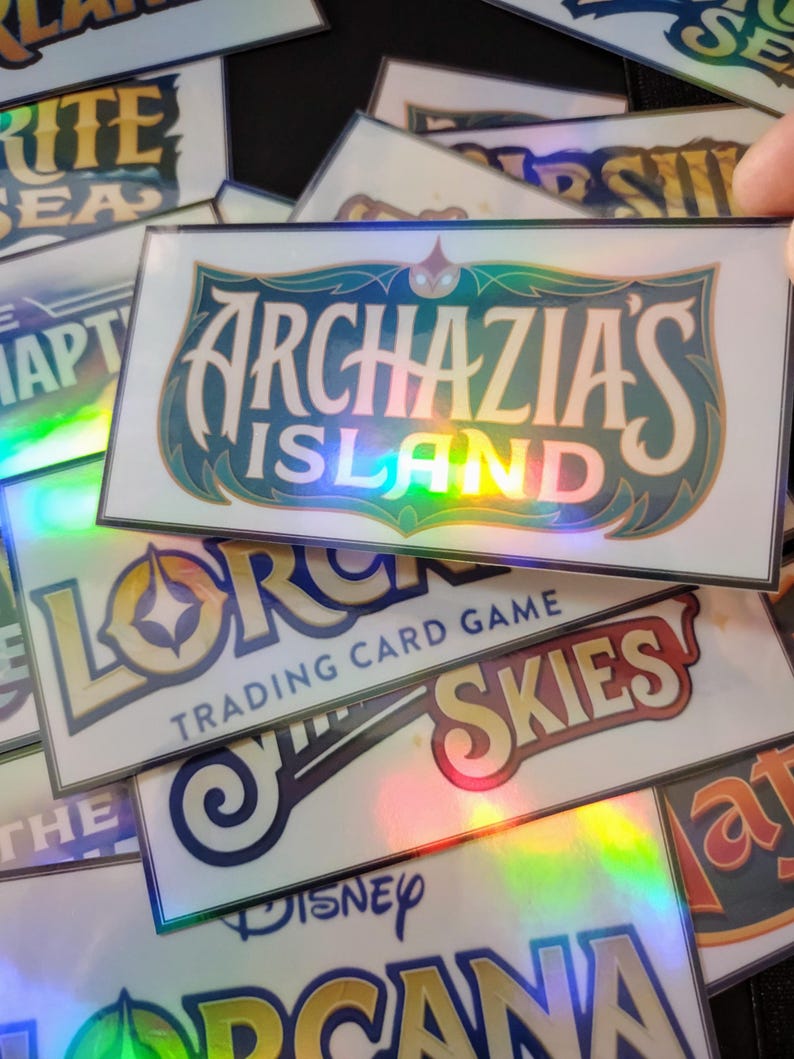 May include: A stack of holographic trading cards featuring various game titles, including "Lorcana Trading Card Game", "Archazia's Island", and "The Disney Lorcana".