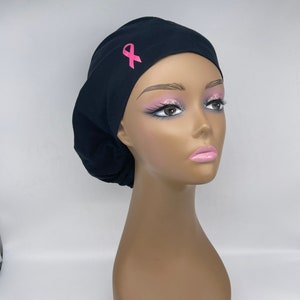 Peut inclure: Un bonnet de travail noir avec un ruban rose. Le bonnet est fait d'un tissu doux et confortable et est parfait pour les professionnels de la santé.