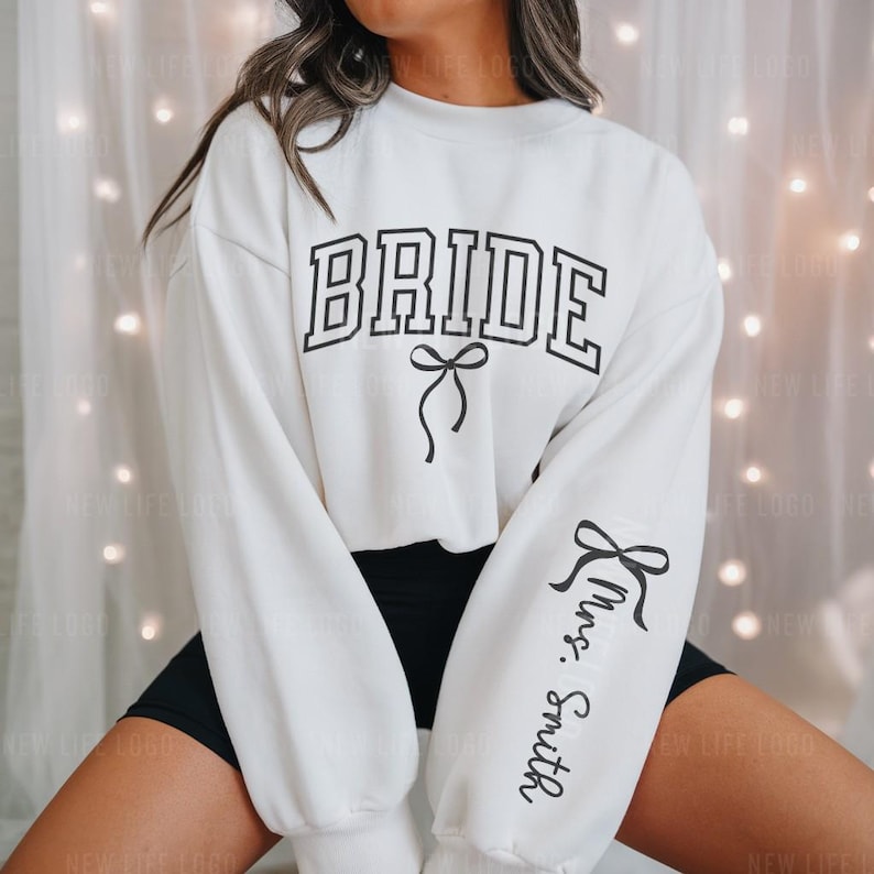 Bride Sweatshirt with black Bow and the Custom Mrs. Last Name on sleeve. Perfect for an engagement.