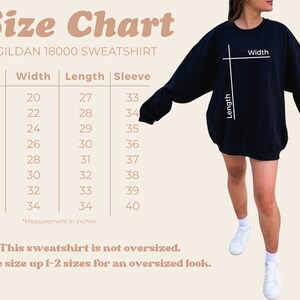 May include: Size chart for a Gildan 18000 sweatshirt, showing measurements in inches for width, length, and sleeve length for sizes S through 5XL. The chart notes that the sweatshirt is not oversized and recommends sizing up 1-2 sizes for an oversized look.