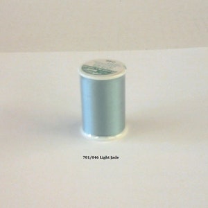 May include: A spool of light jade green thread with a white label that says "701/046 Light Jade".